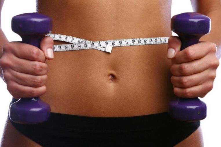 Fitness dumbbells neska egoki baten eskuetan